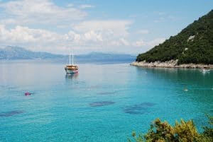 On the edge of green slopes lies the turquoise ocean of Divna Beach