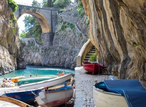 Fiordo di Furore beach in Positano Naples Italy. - Fishermen colored boats on the beach, under the bridge of the fjord. The turquoise water of the beach.