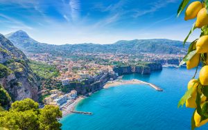 Aerial view of cliff coastline Sorrento and Gulf of Naples, Italy. Ripe yellow lemons in foreground. In Sorrento lemons are used in production of limoncello.