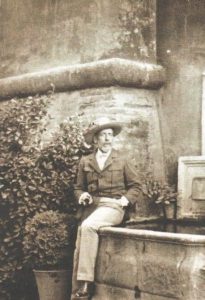 The Duke of San Pedro de Galatino sitting on the edge of a fountain. Image is aged in sepia tones