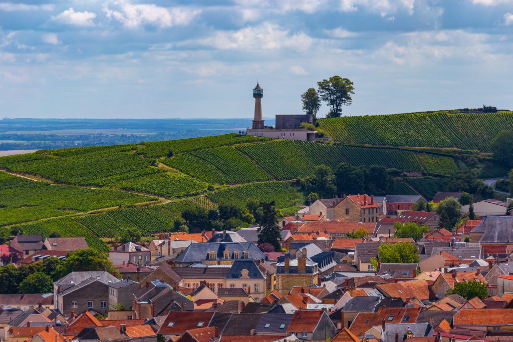 Le Phare lighthouse seen above red rooftops of and green vineyards of the small village Verzenay, close to Reims, Champagne, France