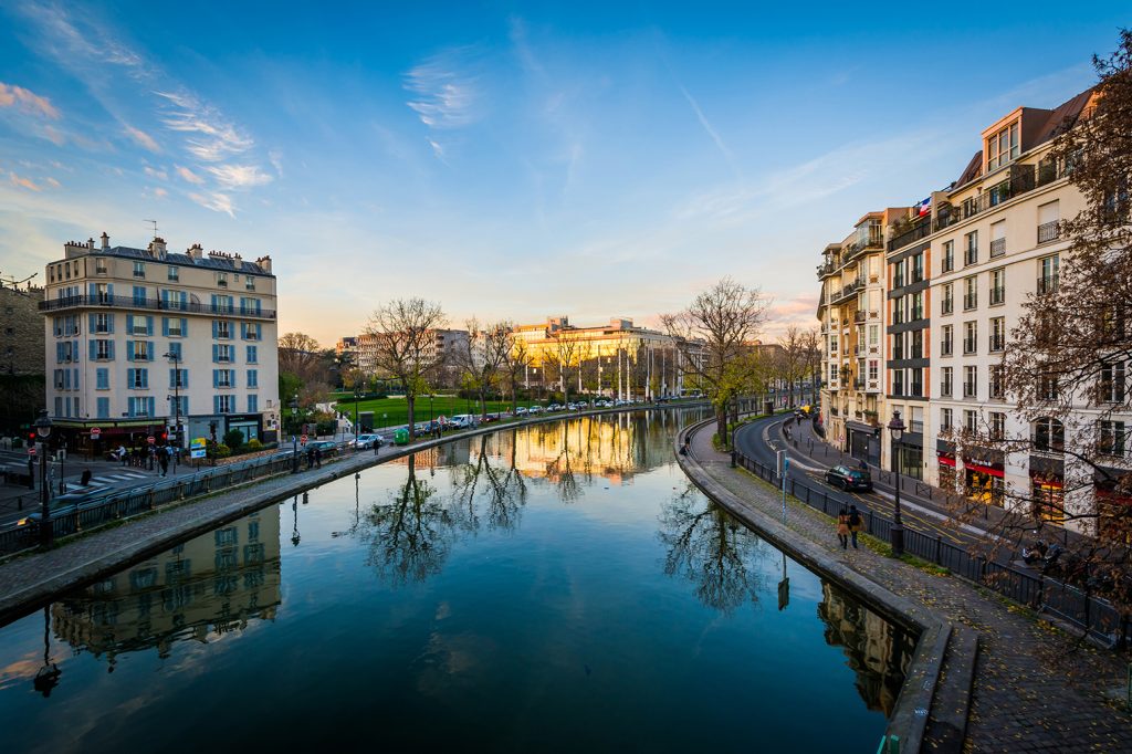 Buildings reflecting in Canal Saint-Martin at sunset, in Paris, France.