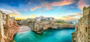 Sunset at Cala Paura gulf with Bastione di Santo Stefano and Lama Monachile beach in background. Polignano a Mare, Apulia, Italy, province of Bari.